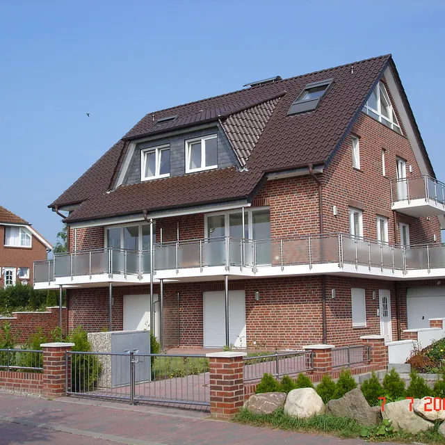 Mehrfamilienhaus mit Klinkerfassade und umlaufenden Balkonen in Schleswig-Holstein – Massivbau durch Bauunternehmen