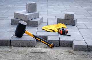 Pflastersteine und Gummihammer bei der Gestaltung von Außenflächen in Ostholstein.