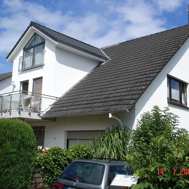 Wohnhaus mit weißer Putzfassade und Balkon in Ostholstein – Umbau und Maurerarbeiten im Bestand
